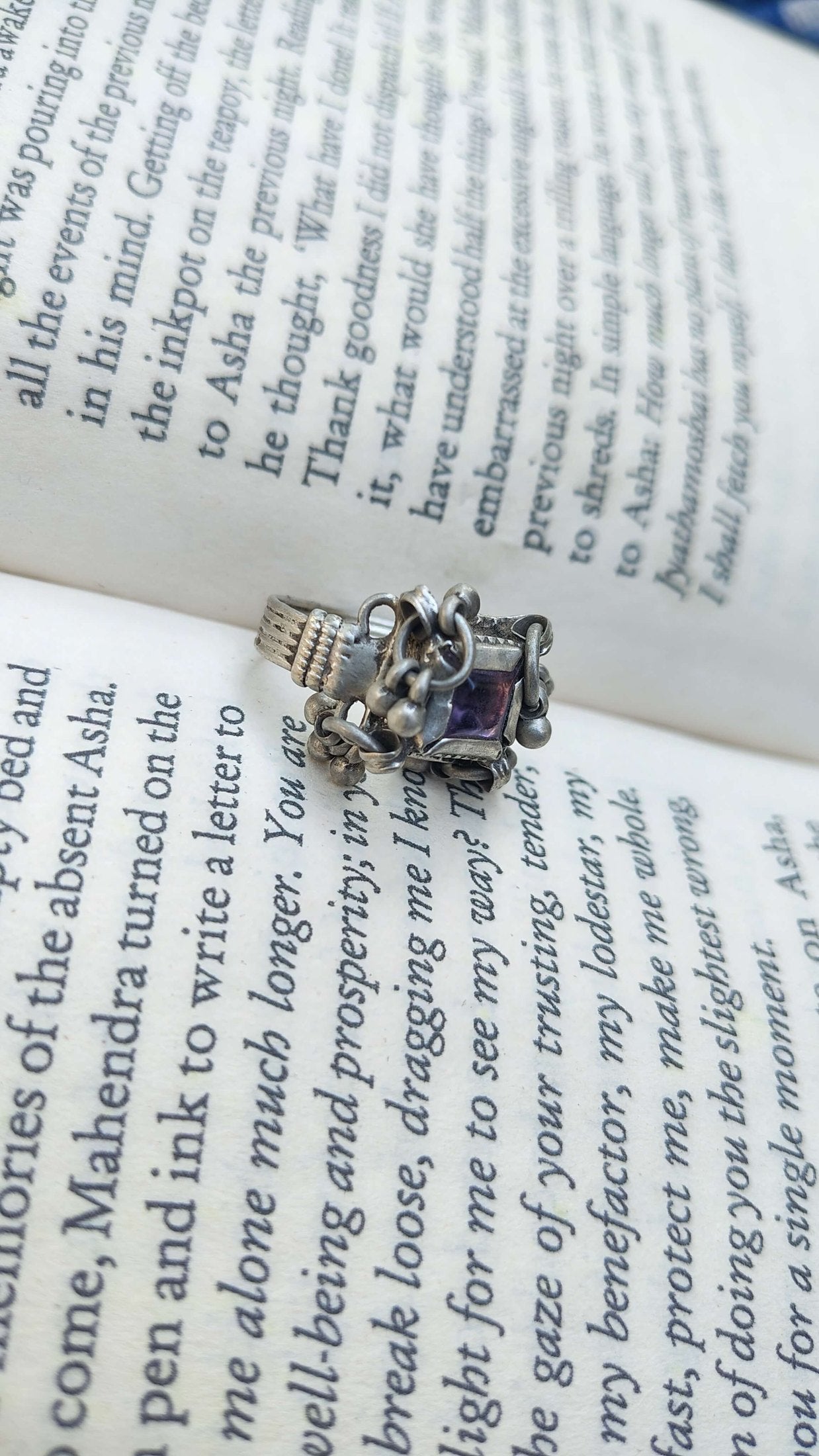 Silver ring with a purple gemstone on an open book, embossed band, and ghungroos | Sadabahaar Jewelry