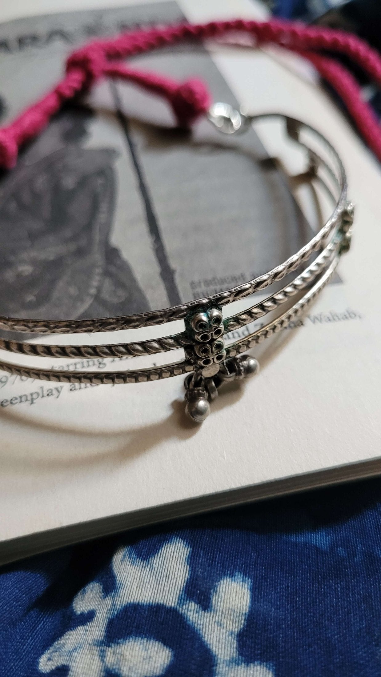 Kosha Vintage Choker on a textured surface with a pink cord.