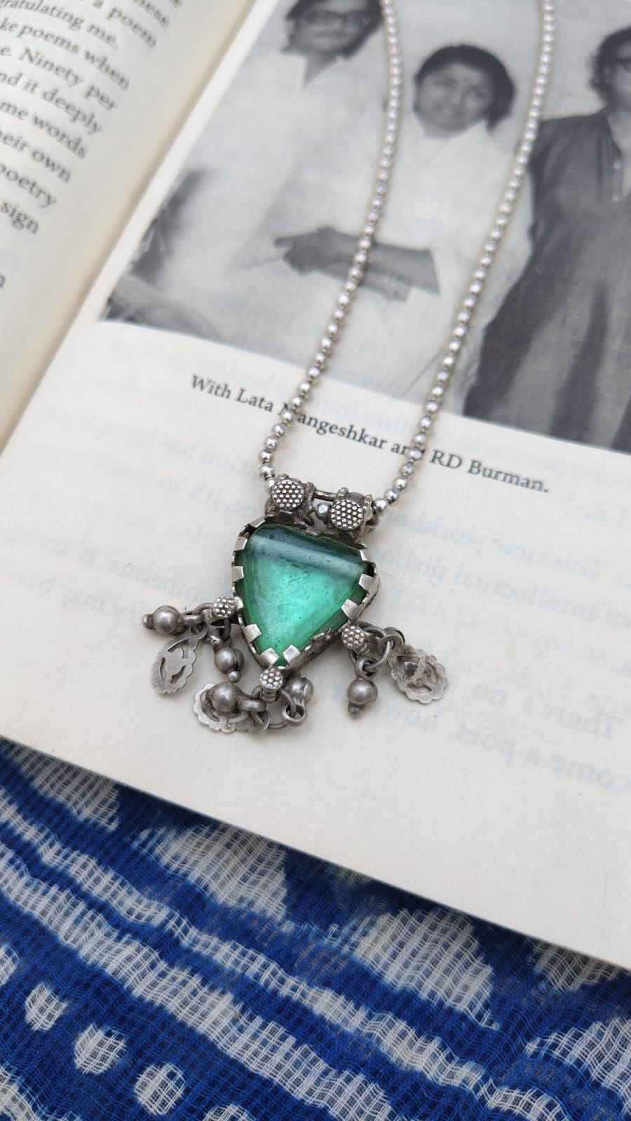 Necklace with a green pendant on an open book