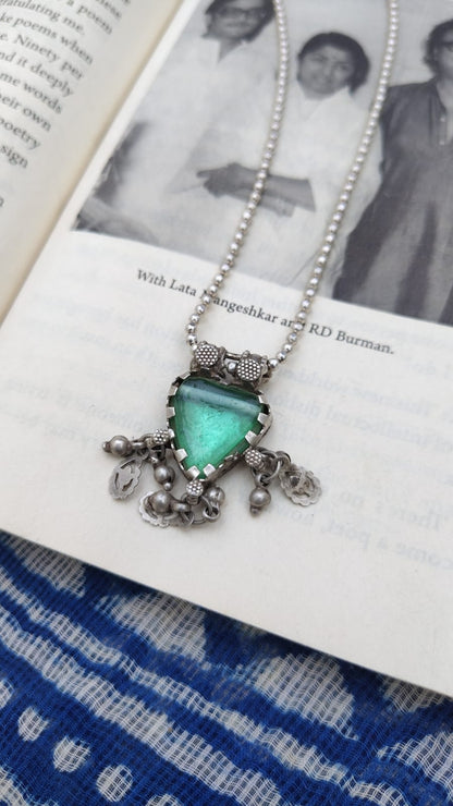 Necklace with a green pendant on an open book