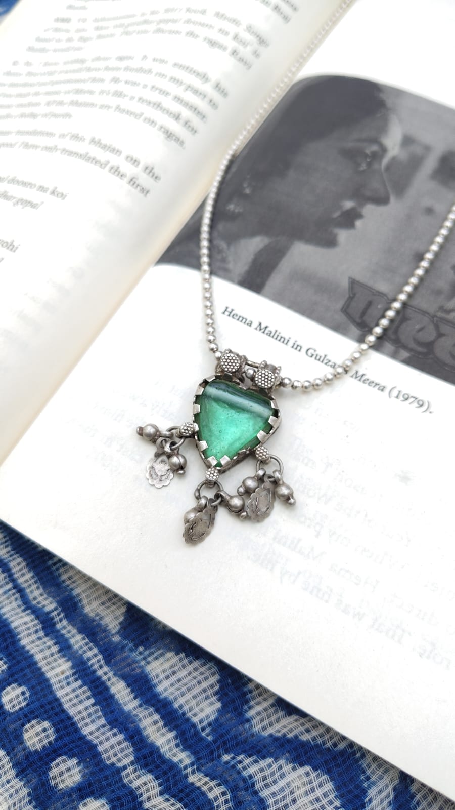 Necklace with a green heart pendant on an open book