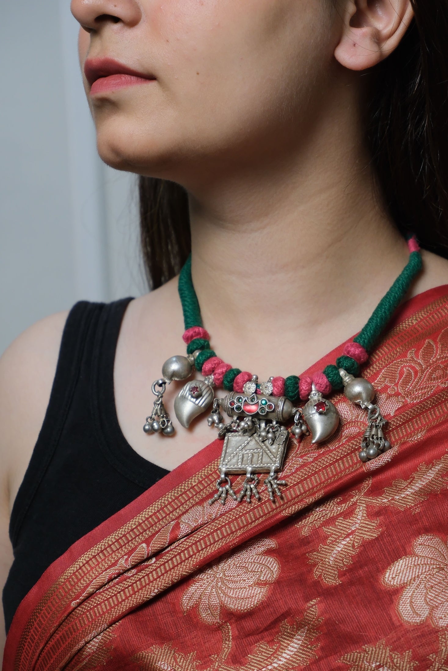 Person wearing a traditional red saree with a black blouse, adorned with Lutf vintage necklace.
