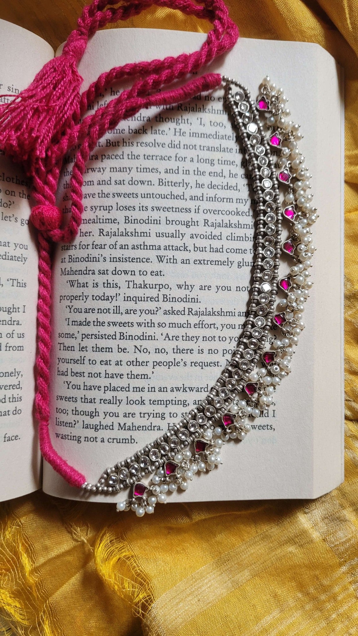 Madhubala Choker Necklace with pink kundan stone and pearls on a book