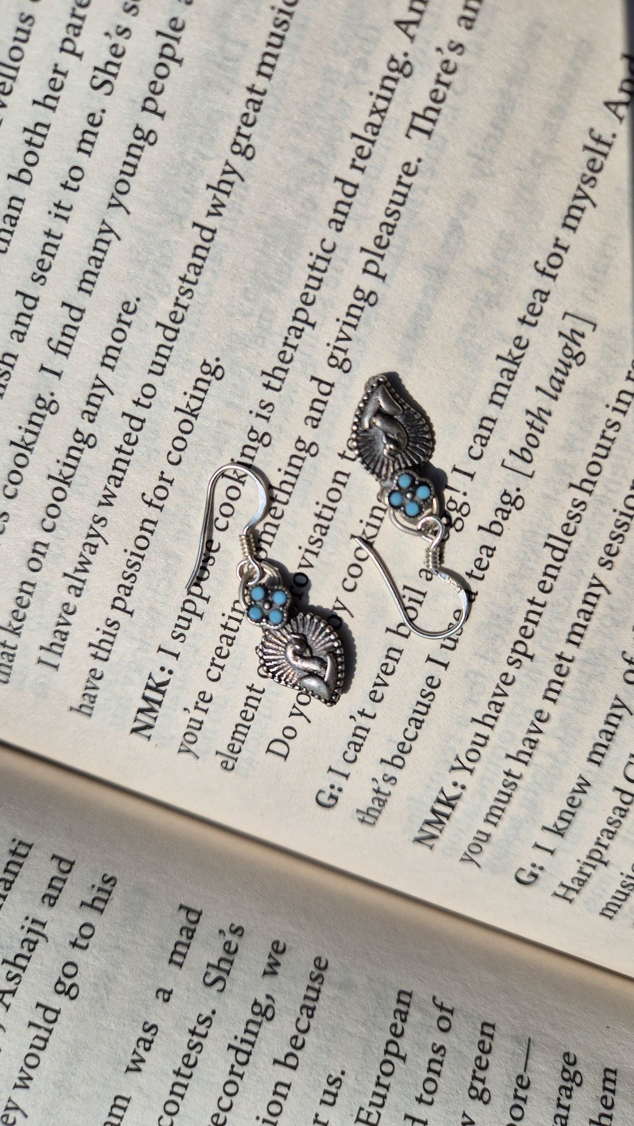 Pair of earrings with blue stones on an open book