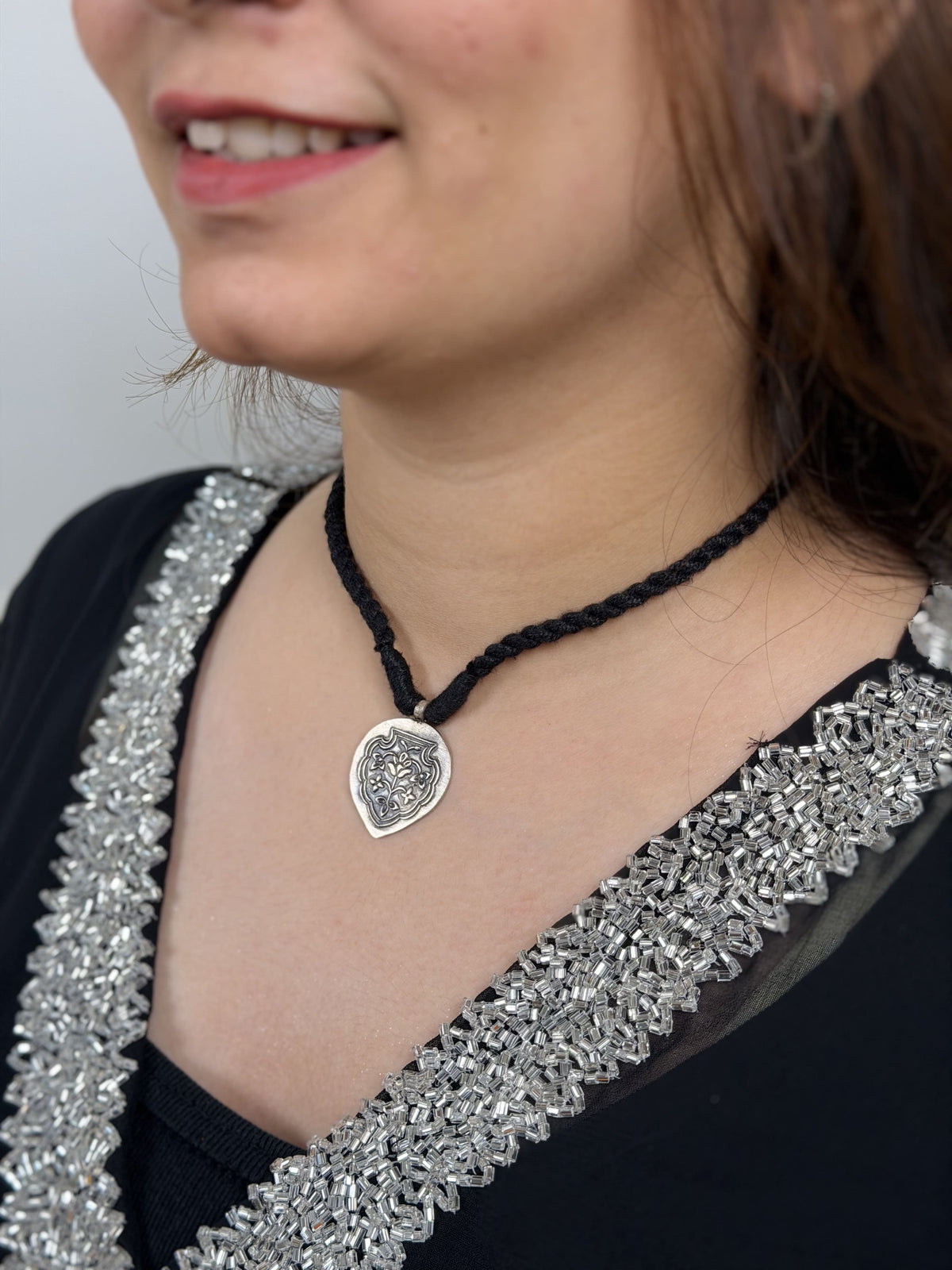 92.5 silver inverted oval pendant with Mughal pietra dura-inspired floral embossing worn.