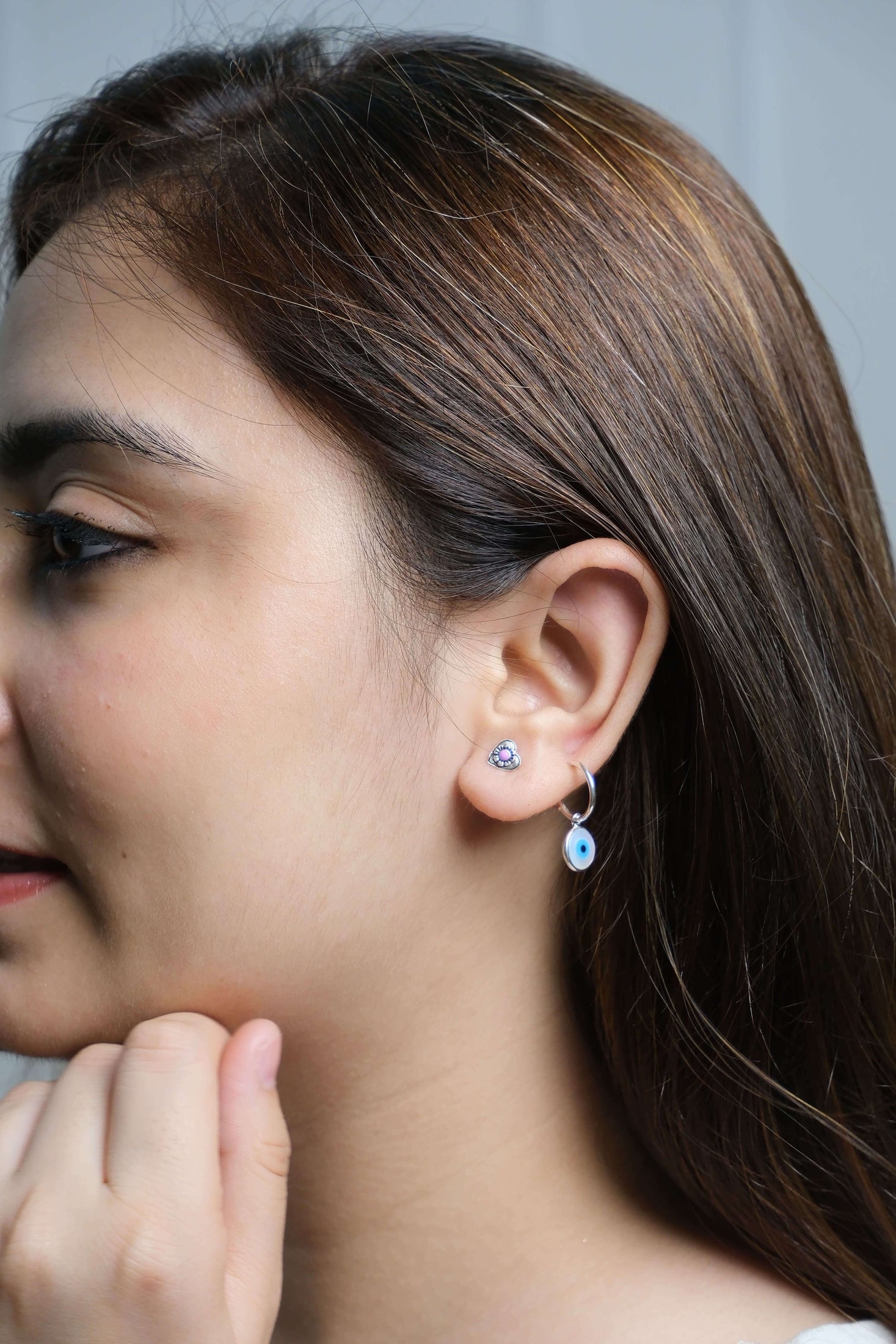 Close-up of a woman wearing 92.5 silver hoops.