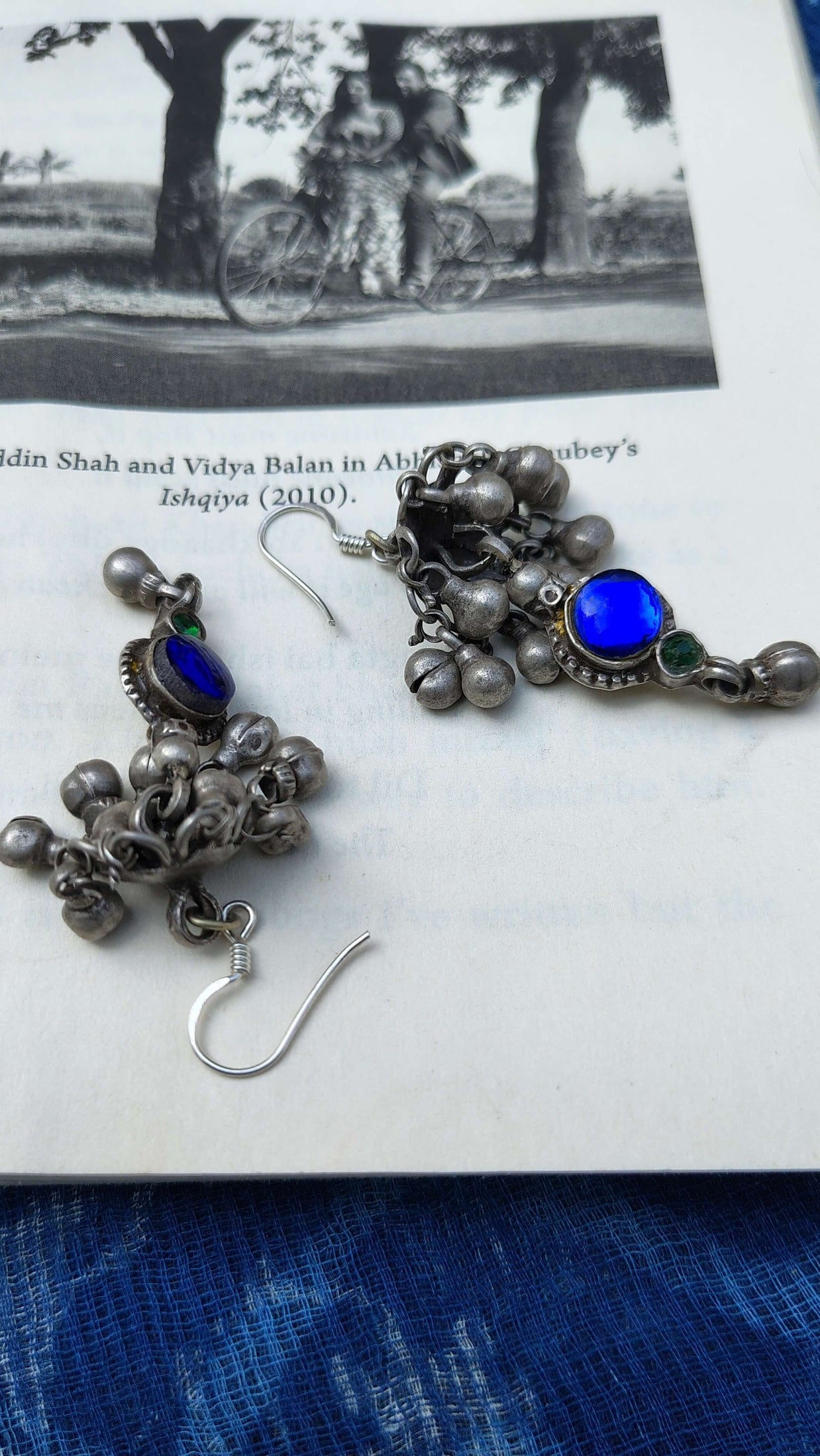 Pair of silver earrings with blue stones on a white surface