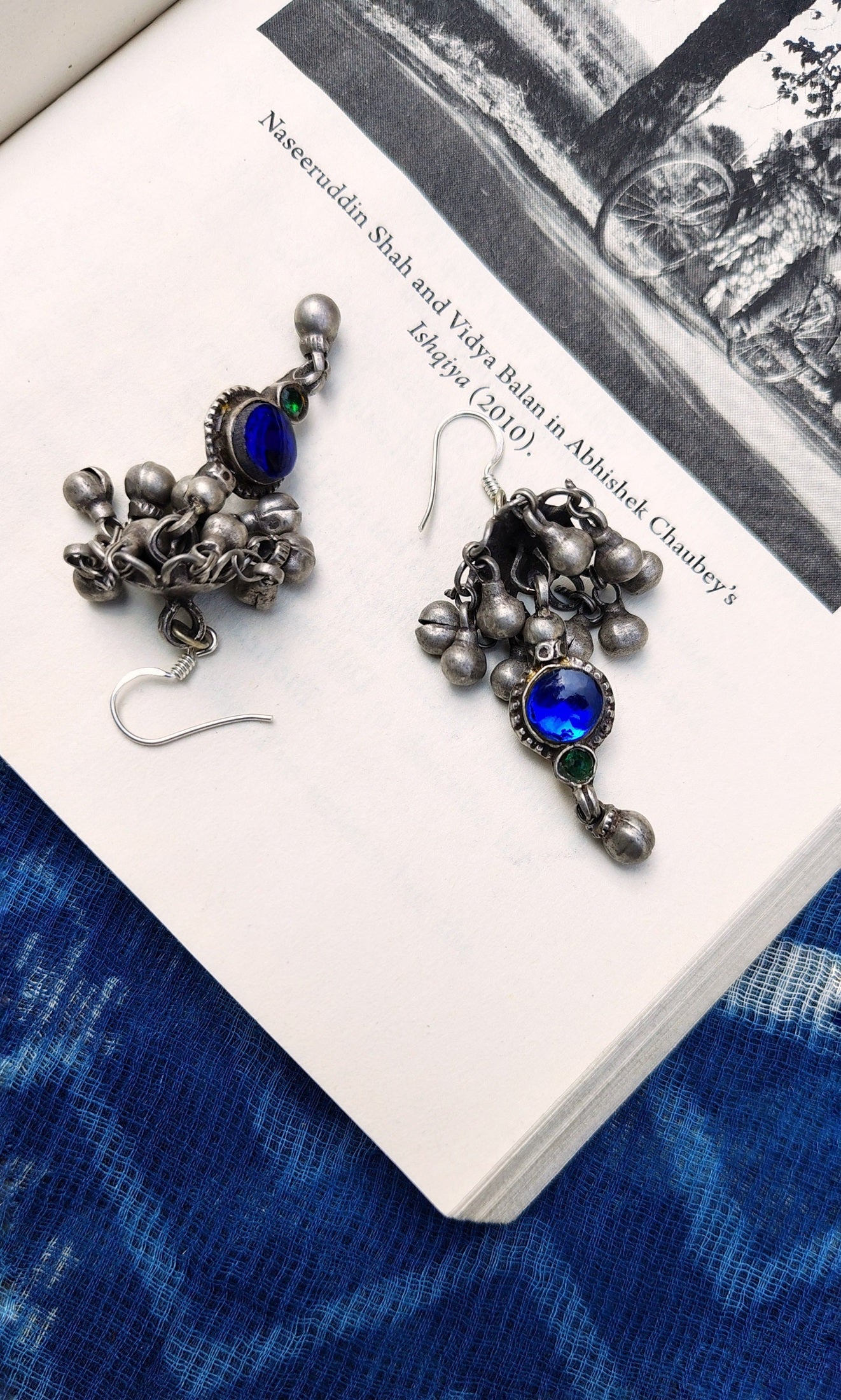 Pair of silver jhumkas on a book