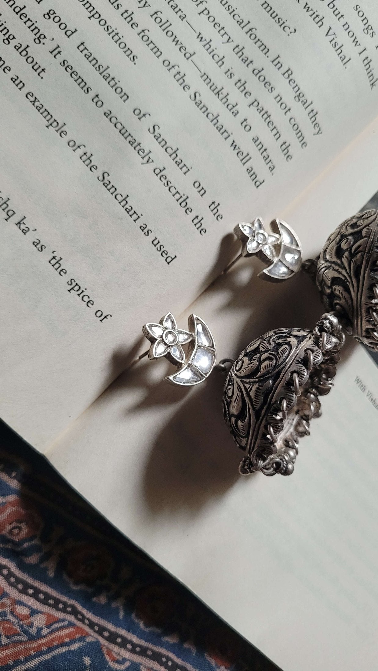 Silver earrings on an open book