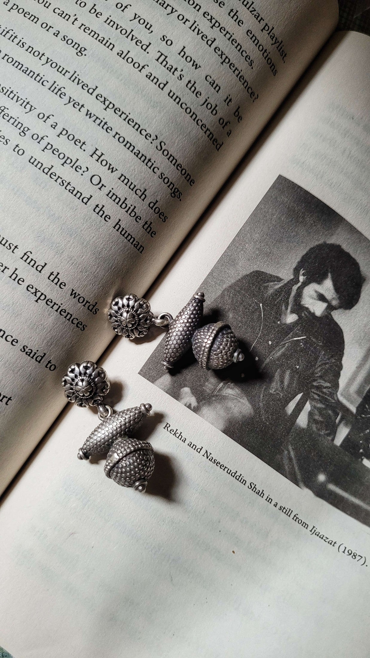 Riddhita Earrings on an open book with a black and white photo of a person.