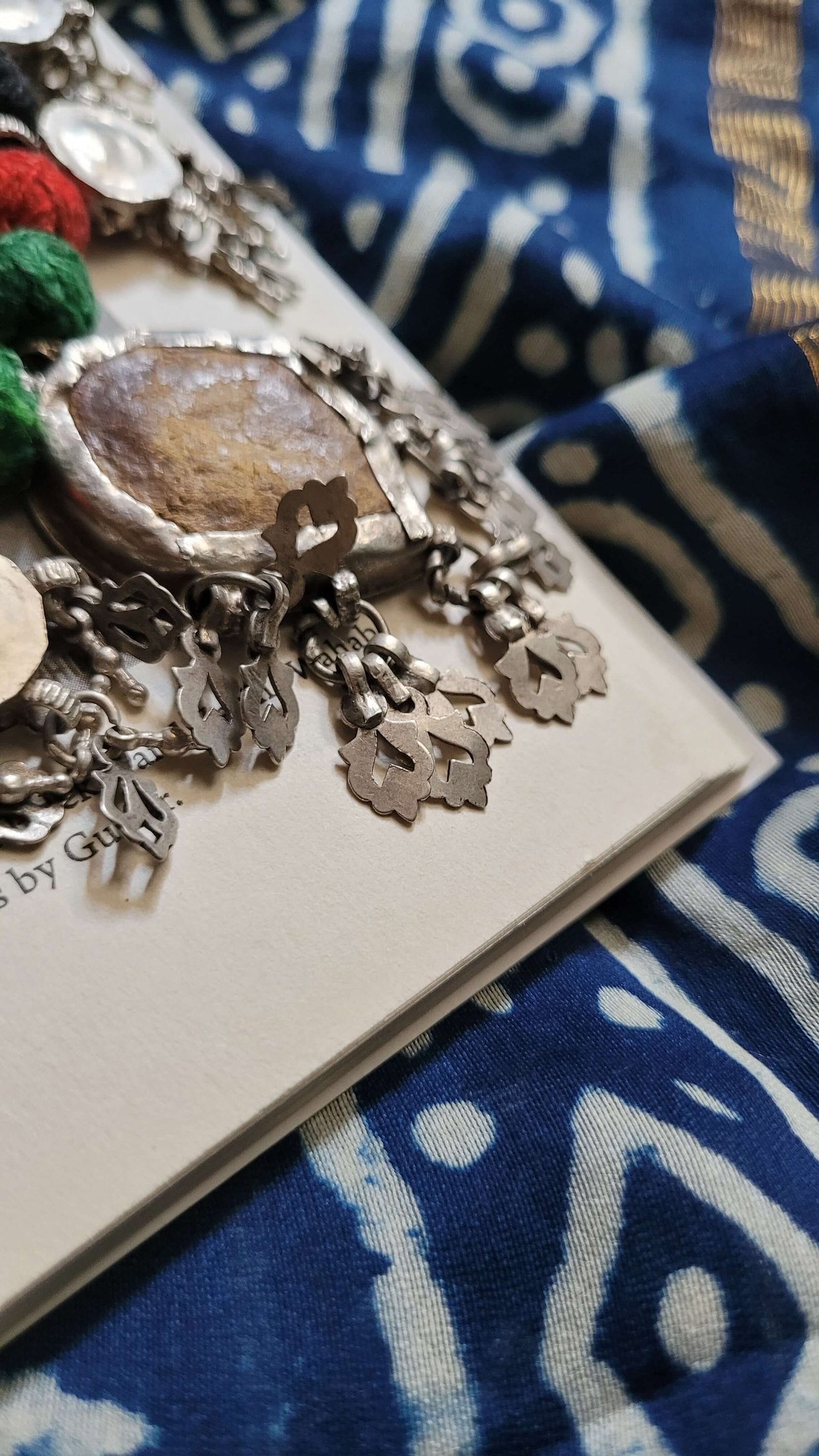 Saaki Vintage Necklace with intricate leaf details on a blue patterned fabric background