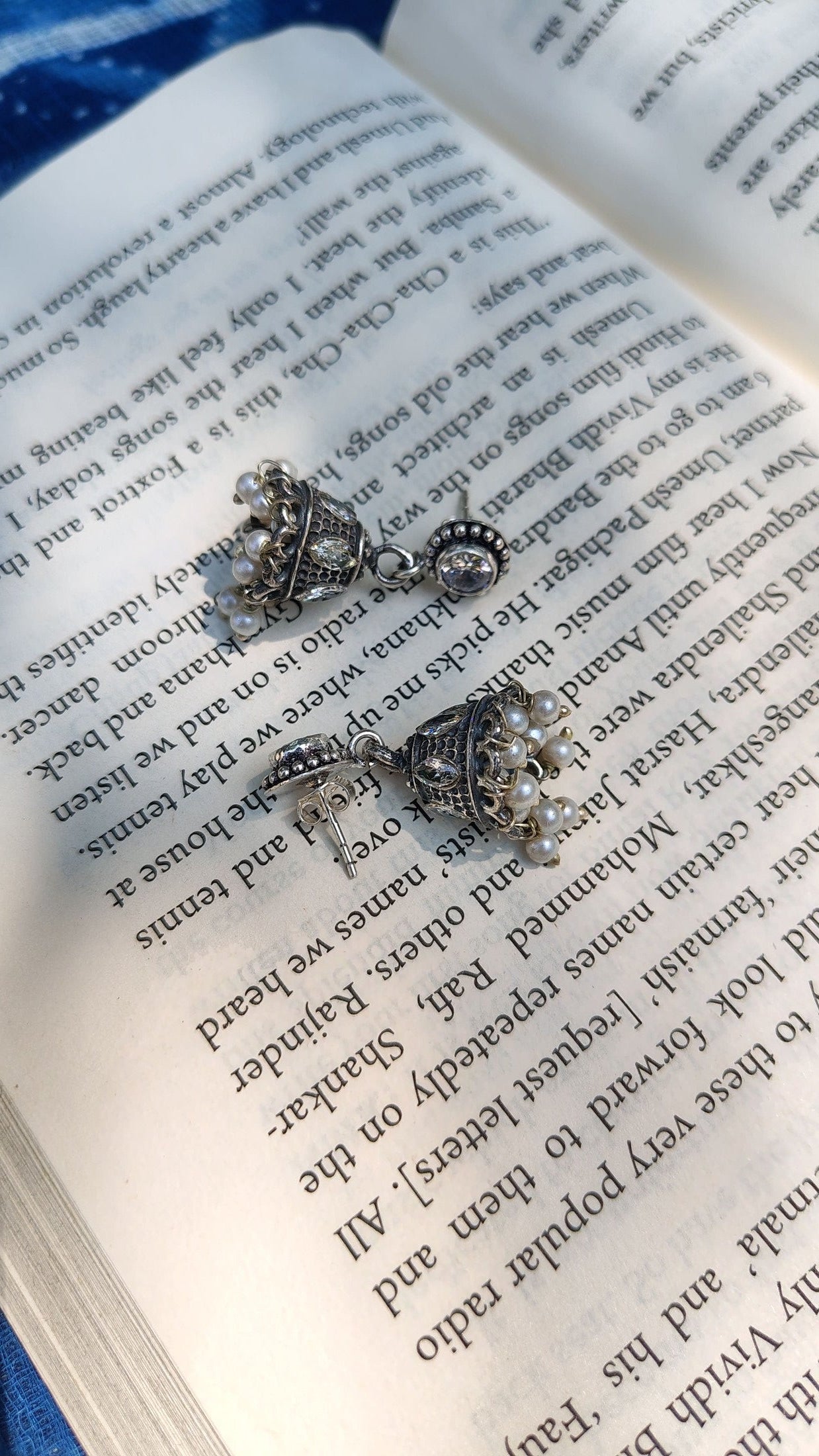 Pair of silver earrings on an open book