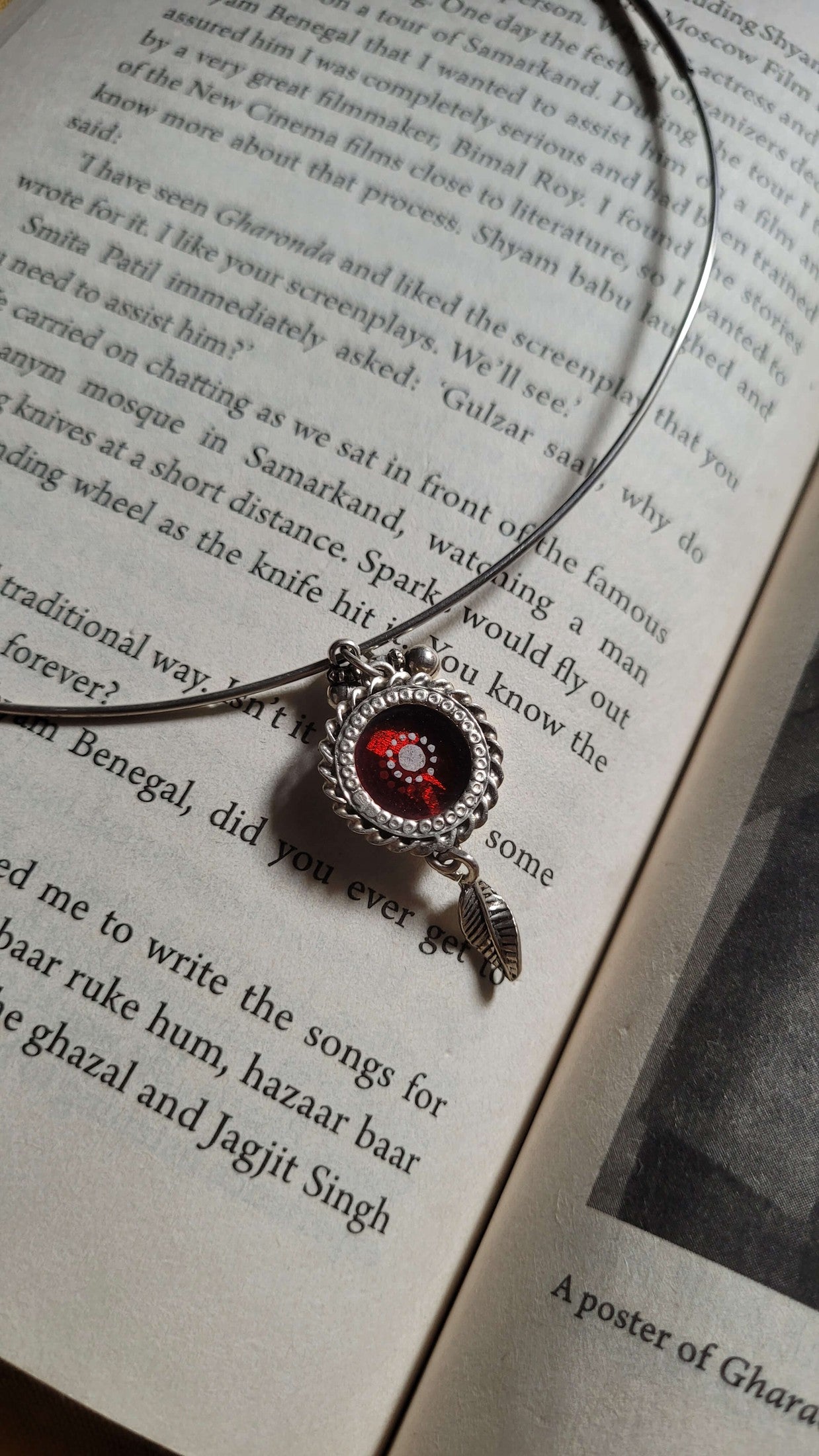 Necklace with a red glass pendant on an open book