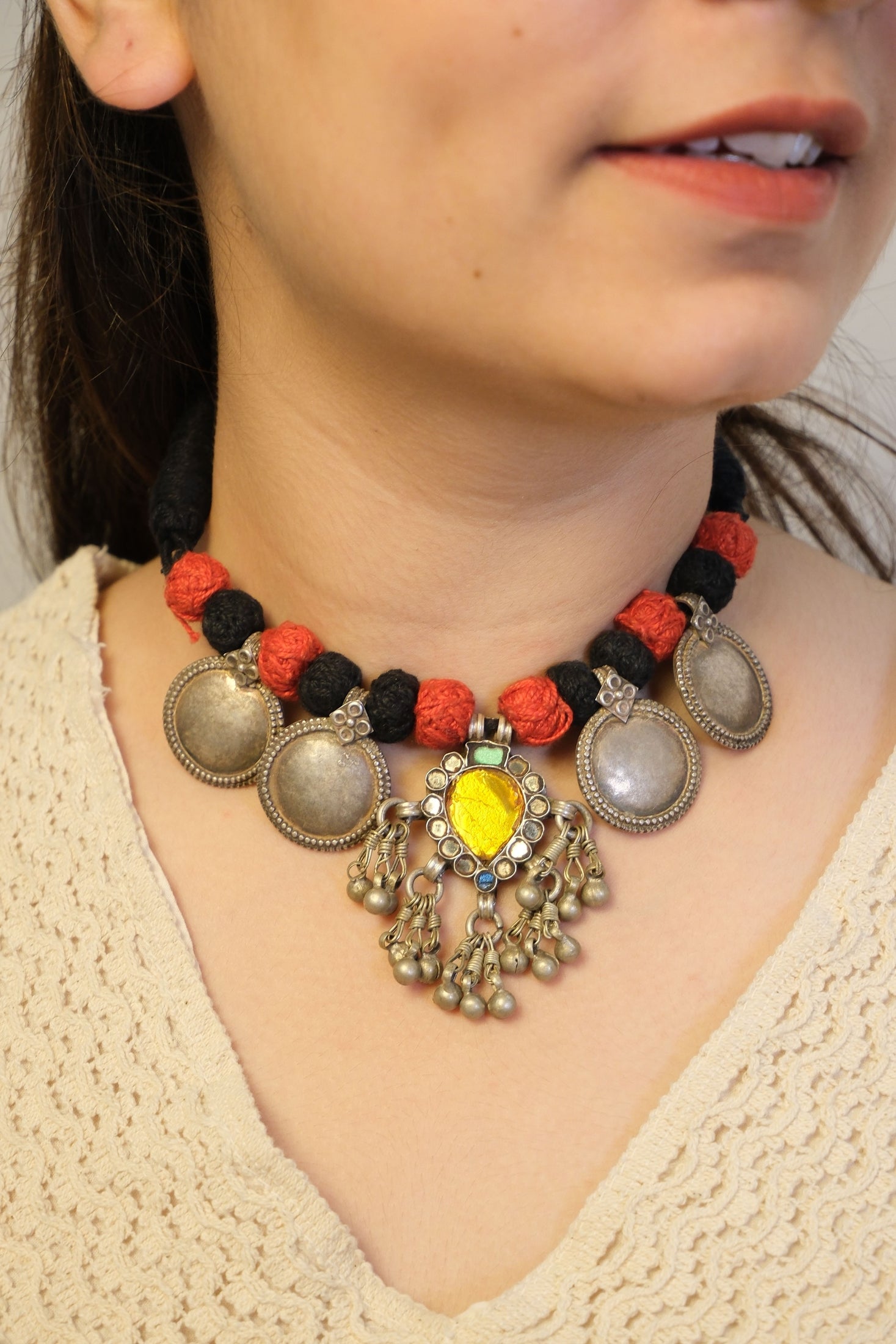 Close-up of a person wearing colorful beaded necklace with decorative elements.