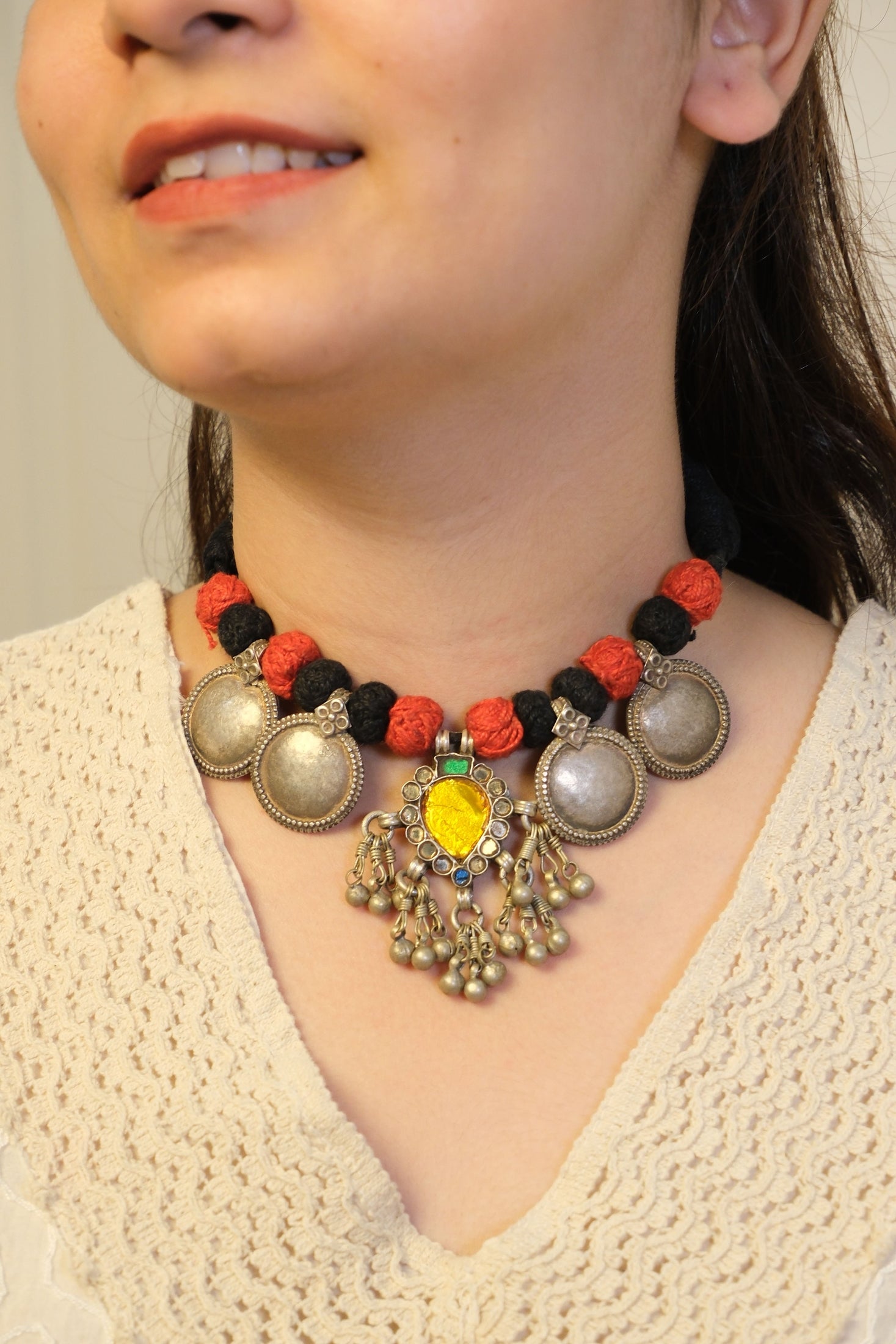 Close-up of a person wearing a colorful beaded necklace with intricate designs.