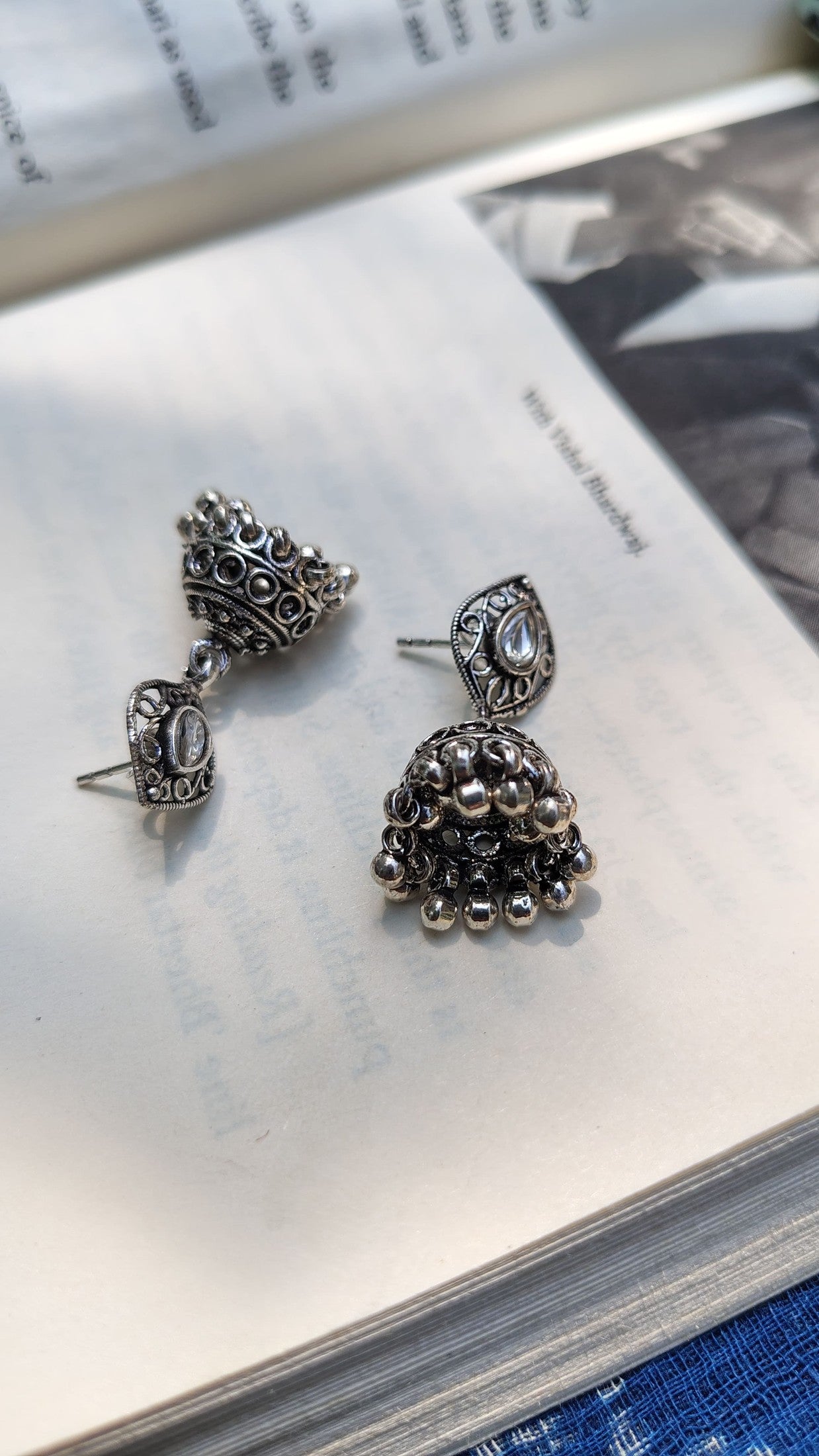 Pair of silver earrings on an open book