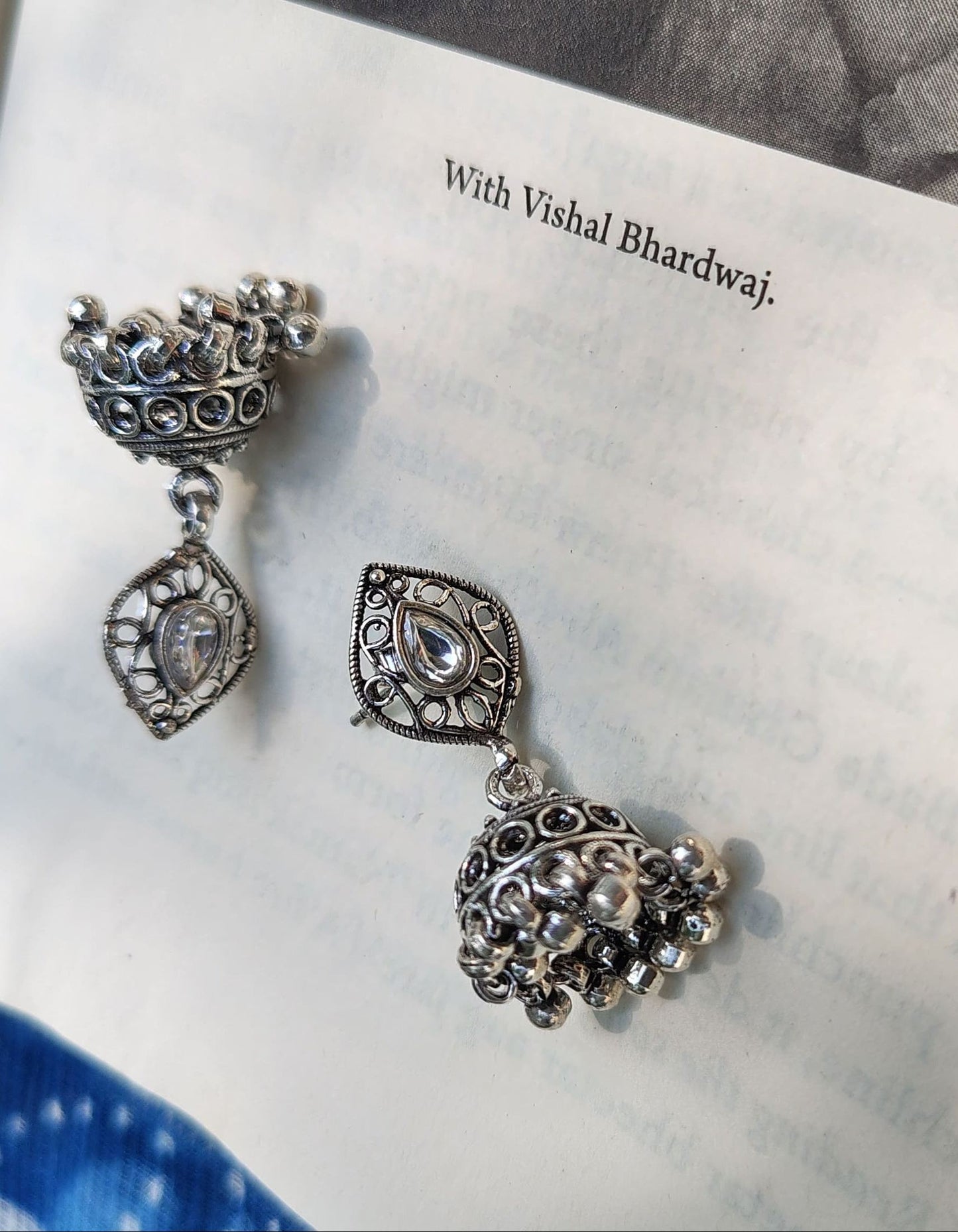 Pair of silver earrings on an open book