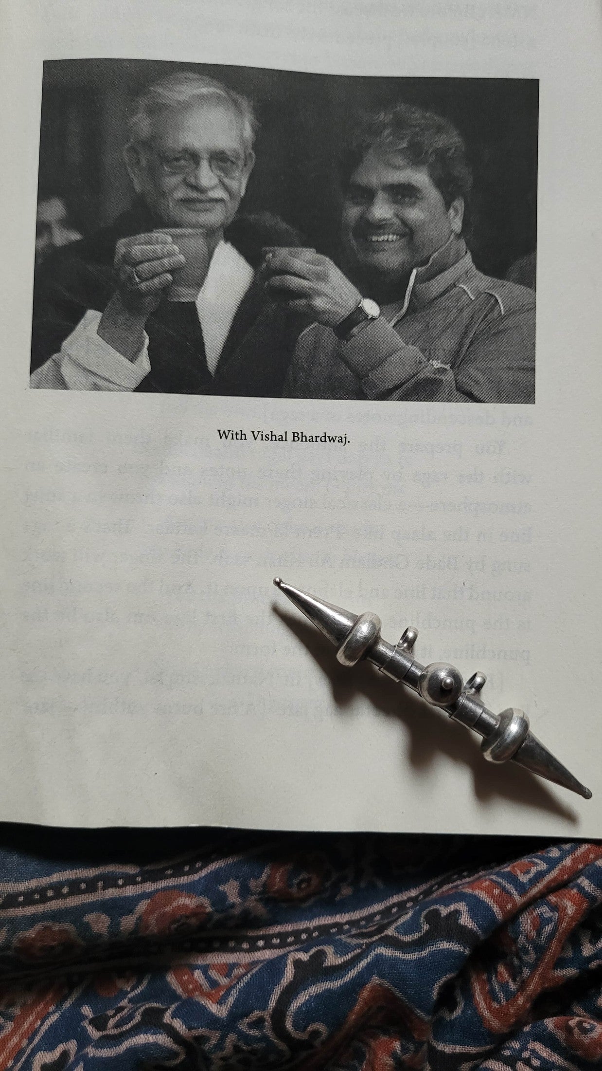 Two men holding glasses with text 'With Vishal Bhandari' on a textured surface with the Tavishi Pendant.