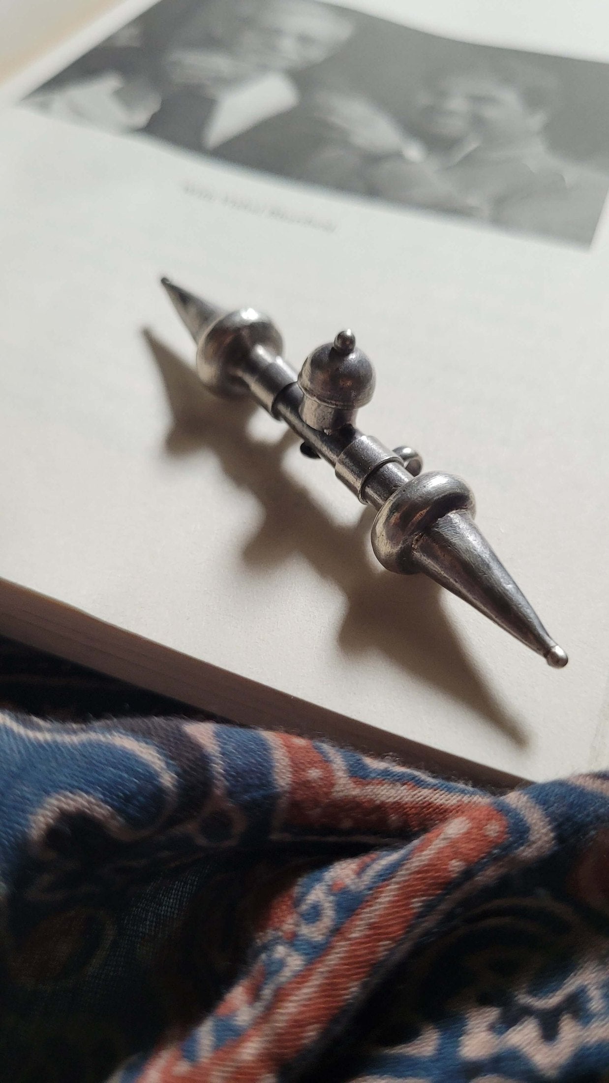 Silver Tavishi Pendant on a surface with a blurred background