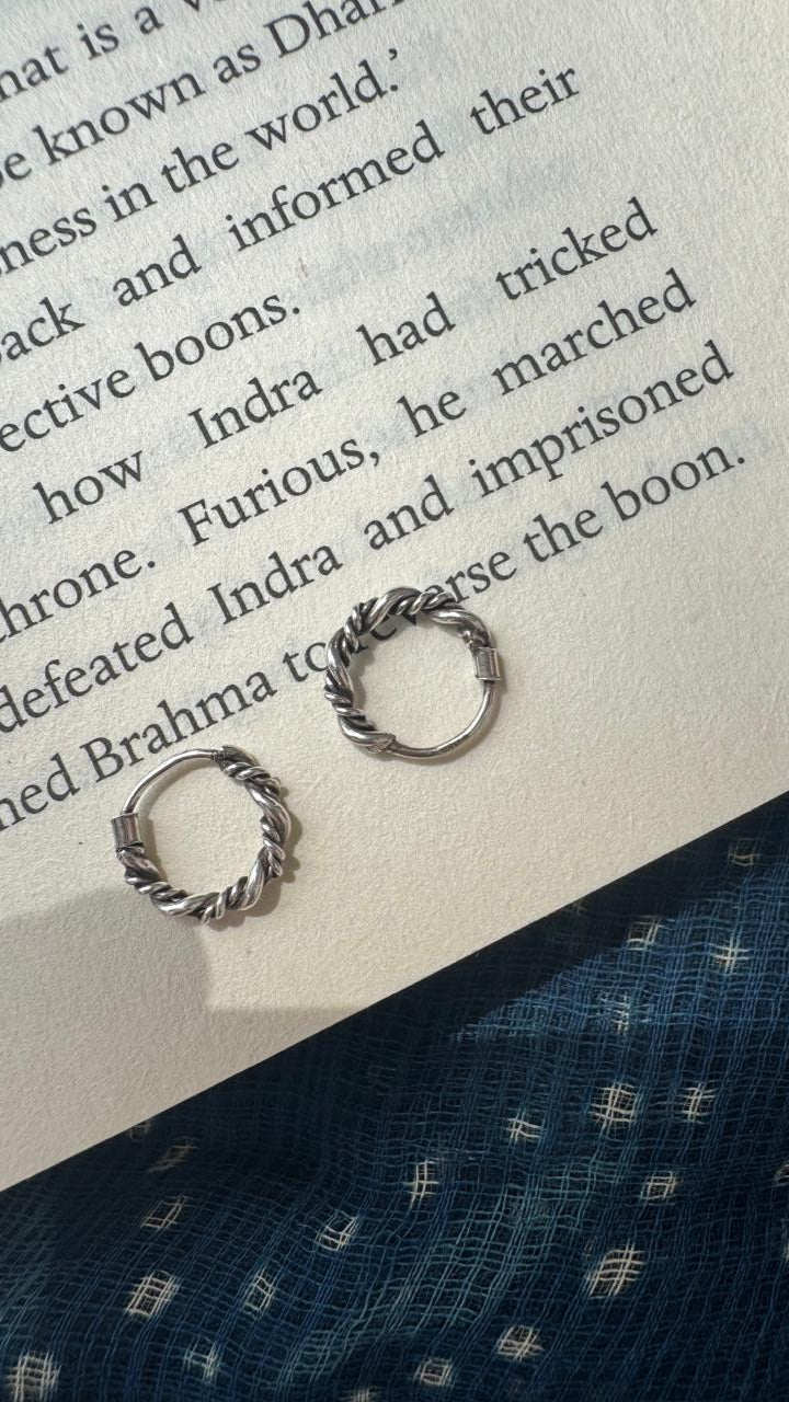 Silver earrings on an open book with text