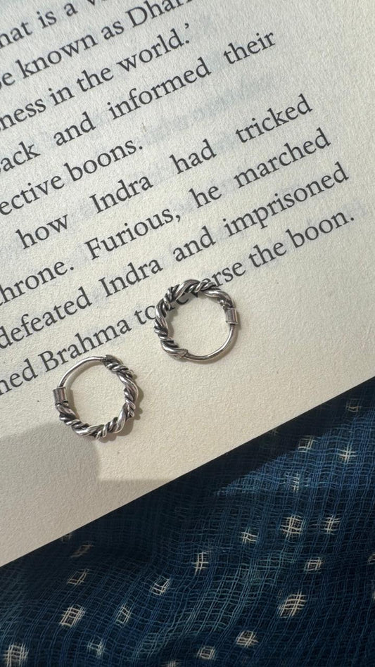 Silver earrings on an open book with text