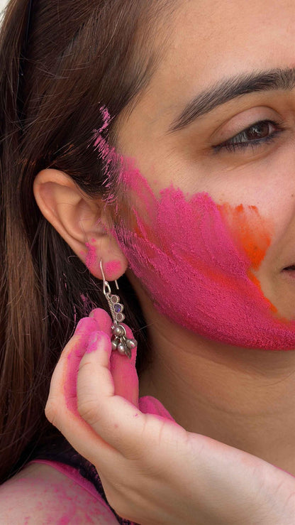 Close-up of a person with colorful face paint and an earring.